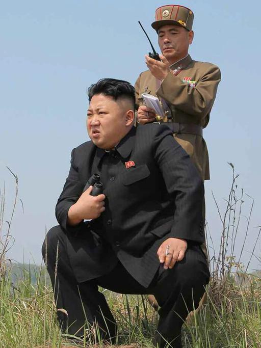 Kim Jong-un kniet bei der Überwachung eine Militärübung.