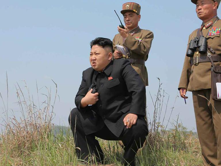 Kim Jong-un kniet bei der Überwachung eine Militärübung.