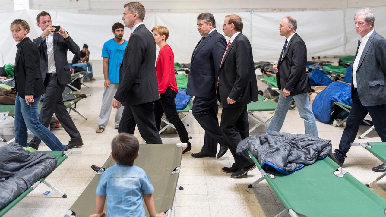 Bundeswirtschaftsminister Sigmar Gabriel, SPD, geht durch eine Notunterkunft für Flüchtlinge im ehemaligen Praktiker-Baumarkt in Heidenau; Aufnahme vom 24. August 2015