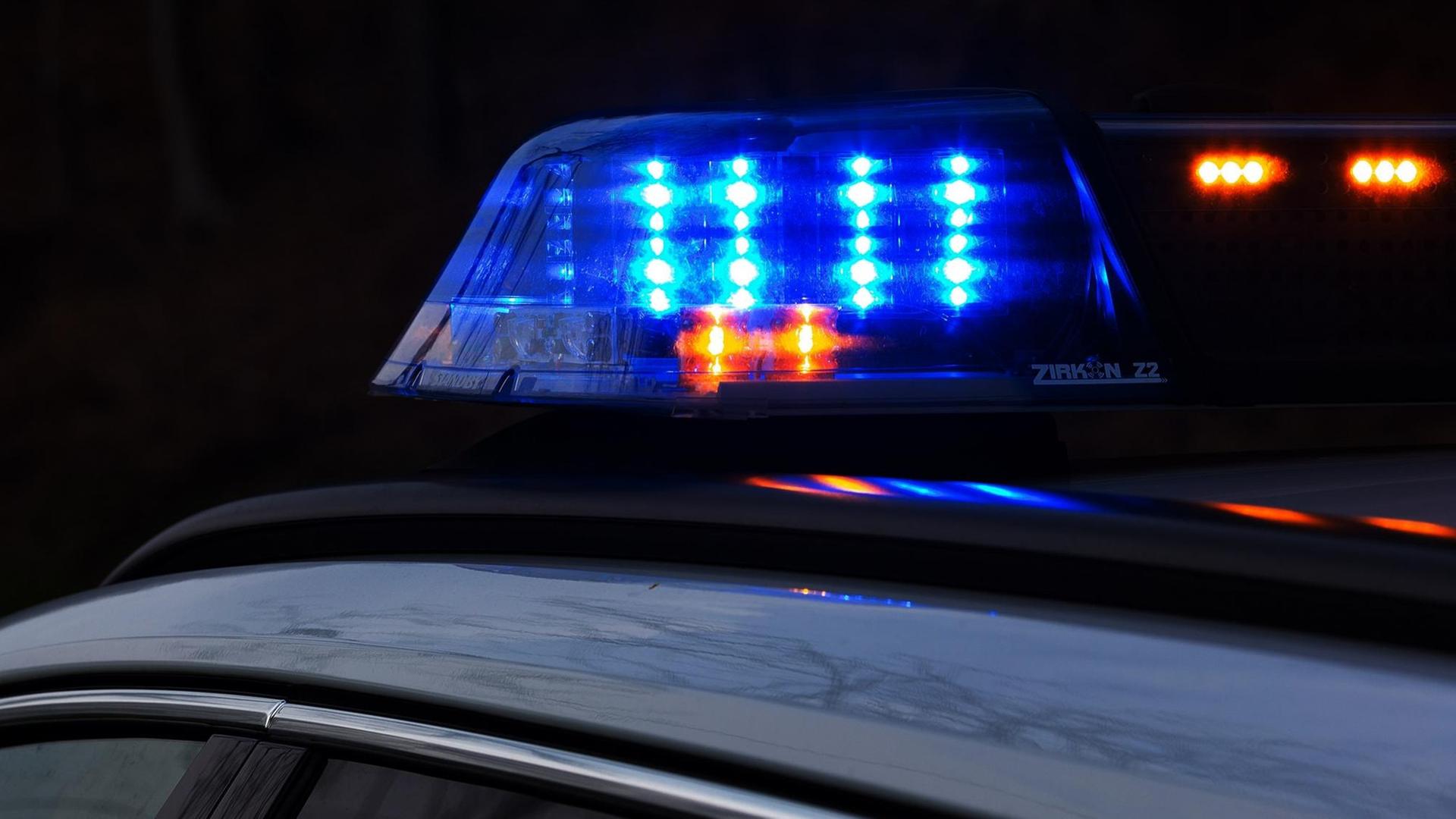 Ein Einsatzfahrzeug der Polizei in der Dunkelheit, mit Blaulicht