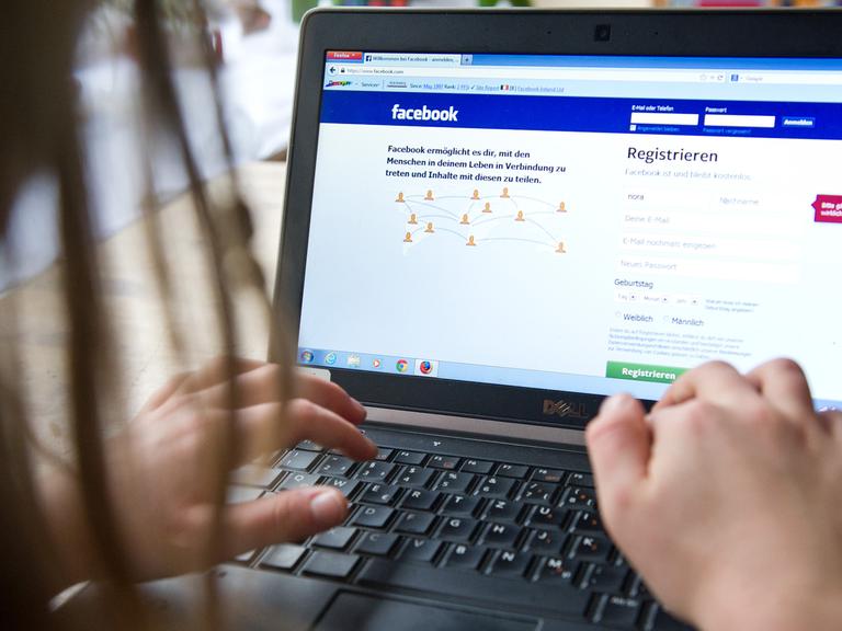 Ein Kind surft an einem Laptop auf der Seite des sozialen Netzwerks "Facebook".