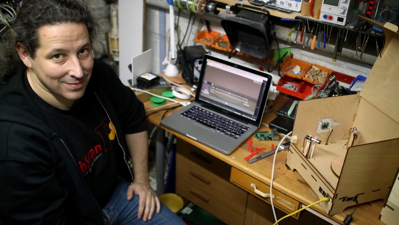 Mario Lukas vor einem Laptop in einem Hobbykeller
