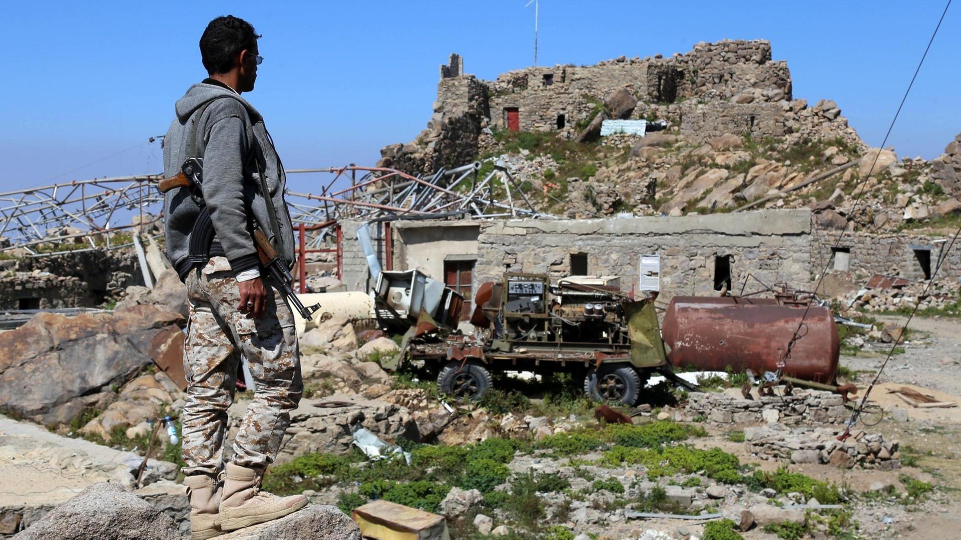 Das Bild von November 2017 zeigt einen bewaffneten Mann, der in der Region Taiz im Jemen auf zerstörte Funkmasten schaut, vermutlich nach einem Luftschlag der saudisch geführten Allianz.