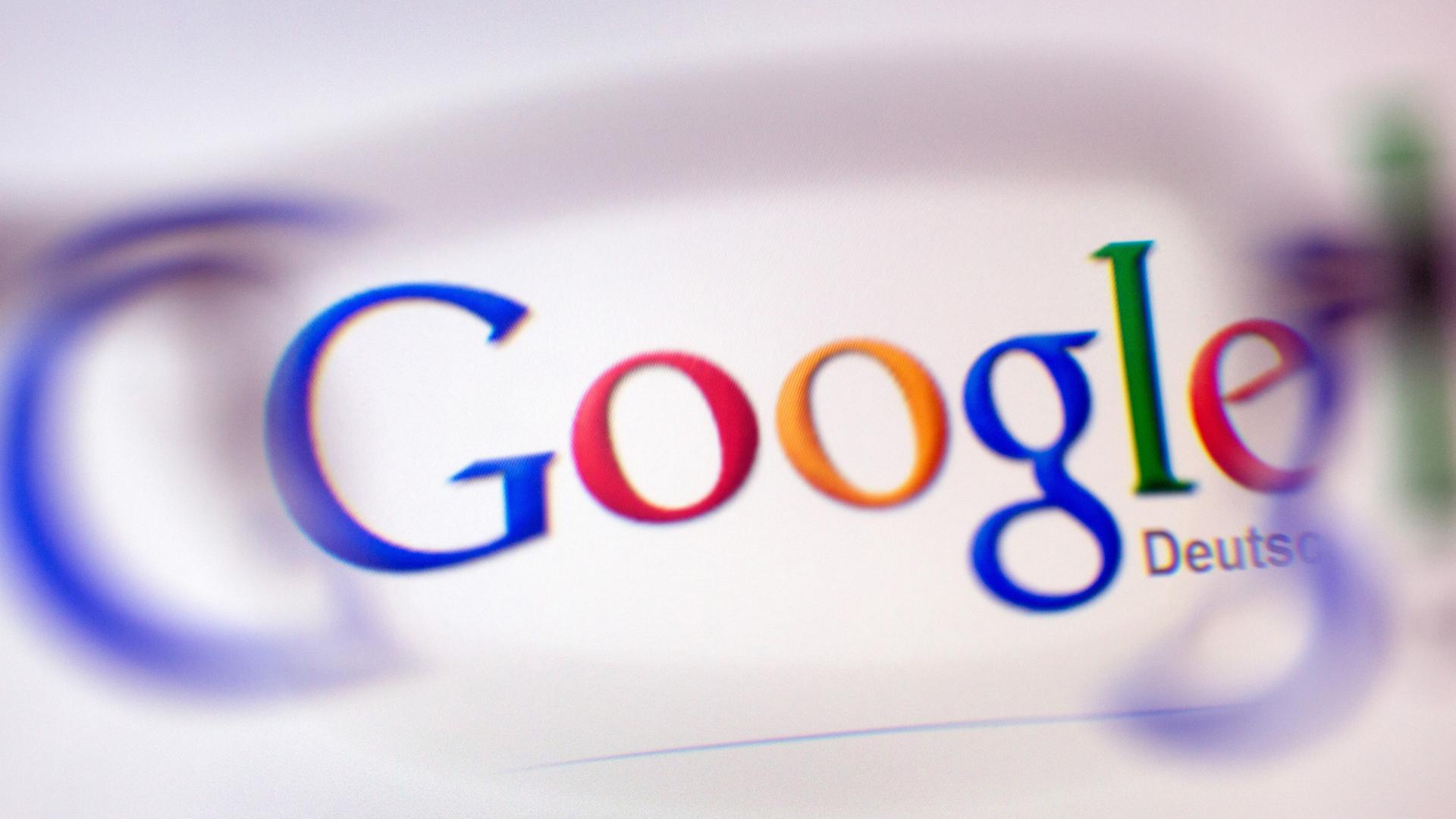 Das Google-Logo ist durch ein Brillenglas auf einem Bildschirm zu sehen. Das Google-Logo ist durch ein Brillenglas auf einem Bildschirm zu sehen.