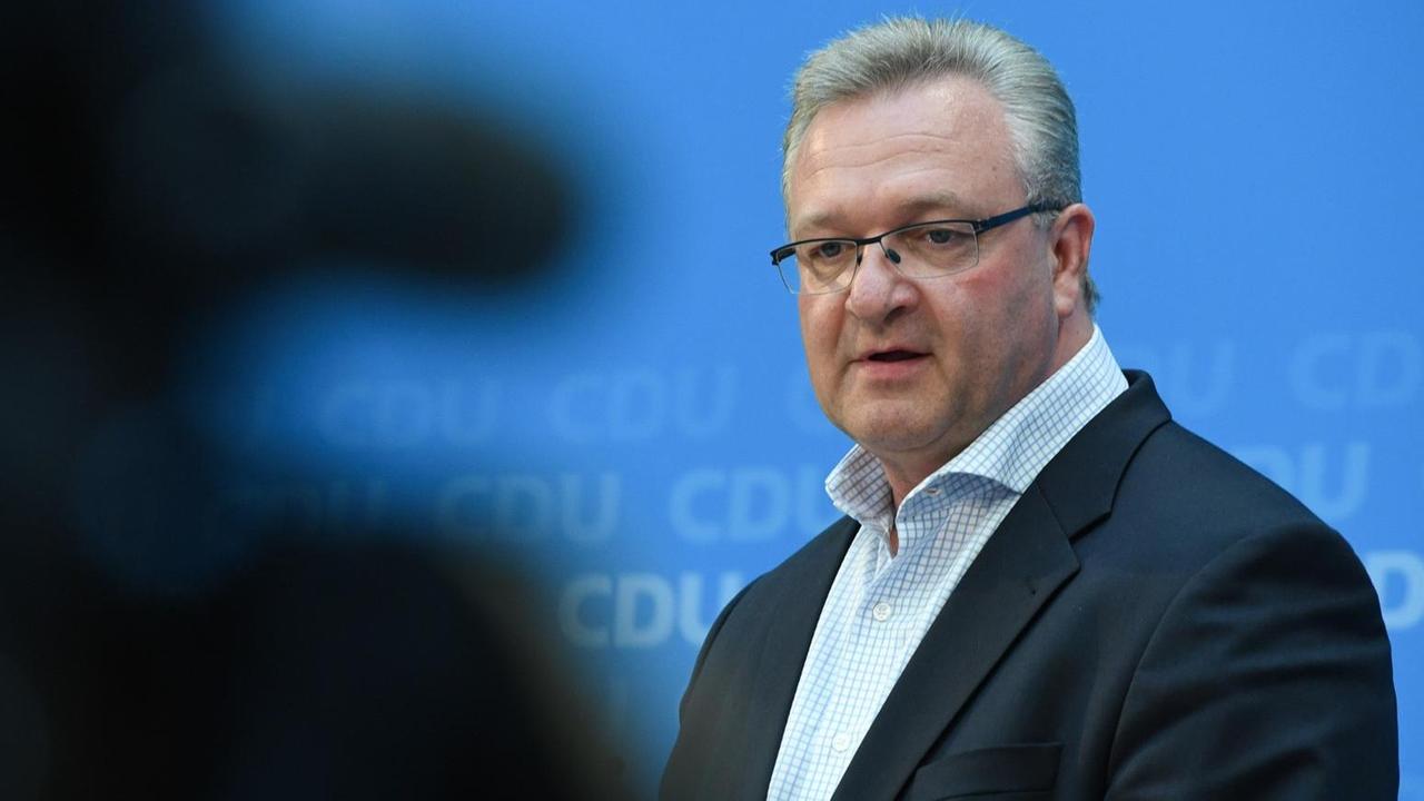 Henkel vor dem blauen CDU-Backdrop, links im Vordergrund sieht man die unscharfe Silhouette eines Fotografen. Henkel vor dem blauen CDU-Backdrop, links im Vordergrund sieht man die unscharfe Silhouette eines Fotografen.