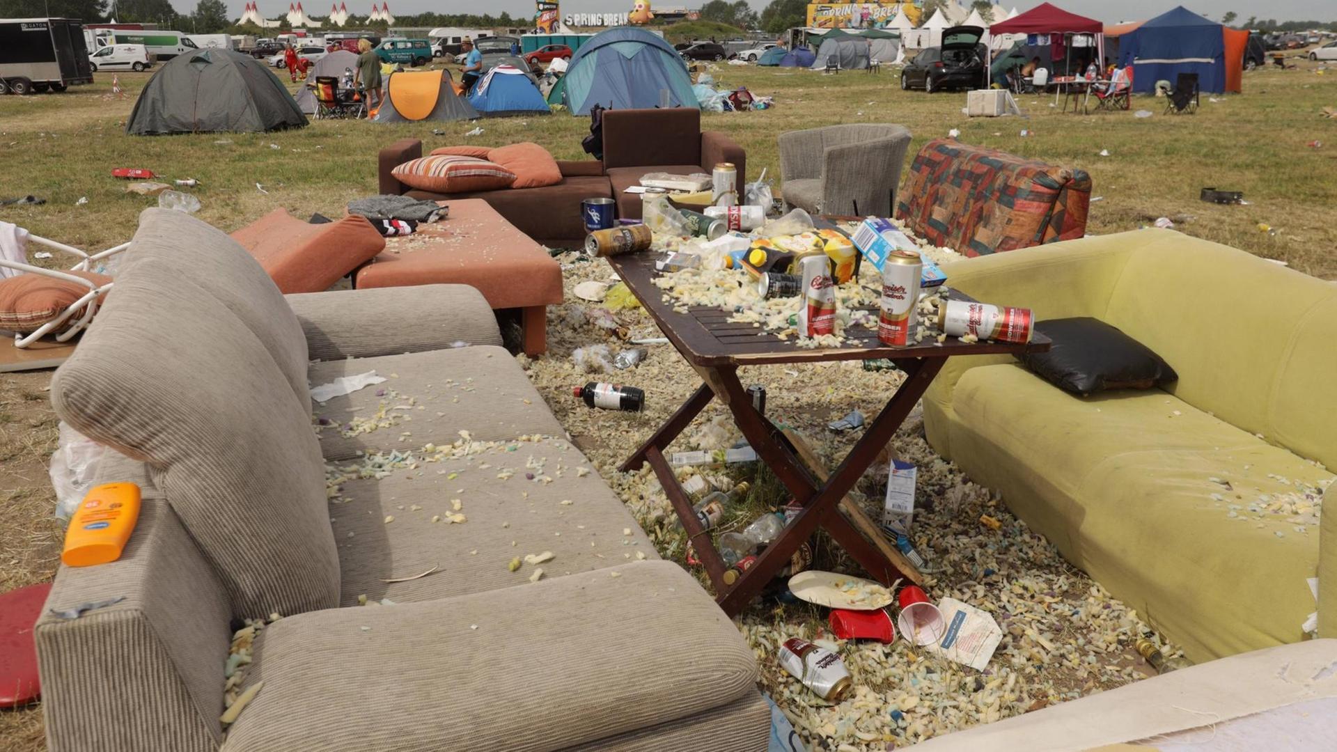 Das Bild zeigt eine vermüllte Campingwiese mit alten Sofas, die nach einem Rockfestival in Bitterfeld zurückgelassen wurden. Das Bild zeigt eine vermüllte Campingwiese mit alten Sofas, die nach einem Rockfestival in Bitterfeld zurückgelassen wurden.