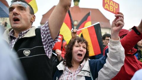 Demonstranten protestieren am 06.09.2017 in Finsterwalde (Brandenburg) auf dem Marktplatz während einer Wahlkampfveranstaltung der CDU gegen Bundeskanzlerin Angela Merkel, eine Frau trägt dabei ein Schild mit der Aufschrift "Hau ab!"