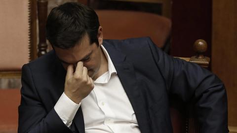 Griechenlands Ministerpräsident Alexis Tsipras senkt den Kopf und reibt sich mit zwei Fingern die Nasenwurzel.
