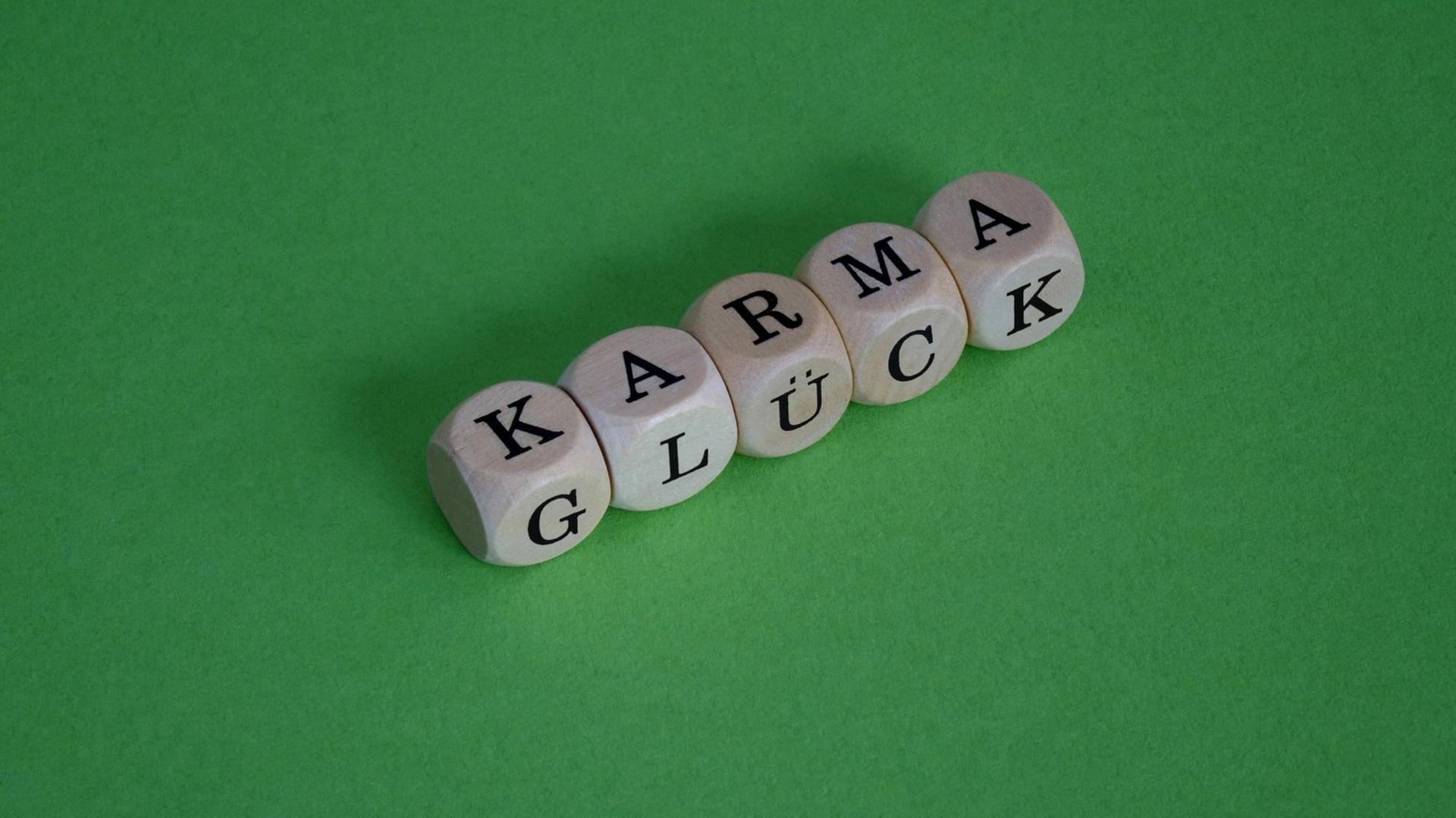 Würfel zeigen zusammengesetzt die Wörter Karma und Glück
