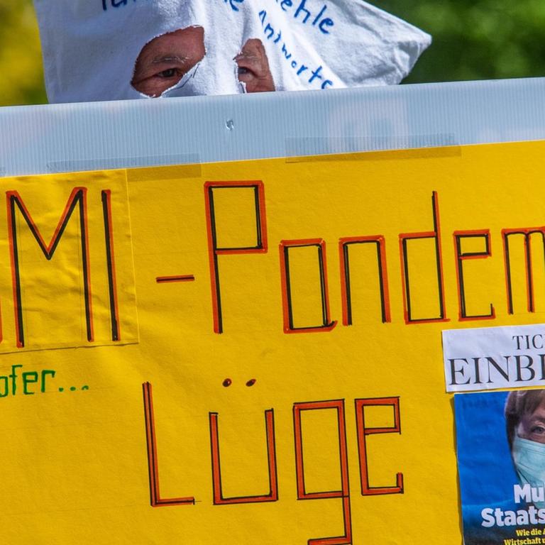Schwerin: Ein Demonstrant mit einer Tüte auf dem Kopf und einem Schild in der Hand