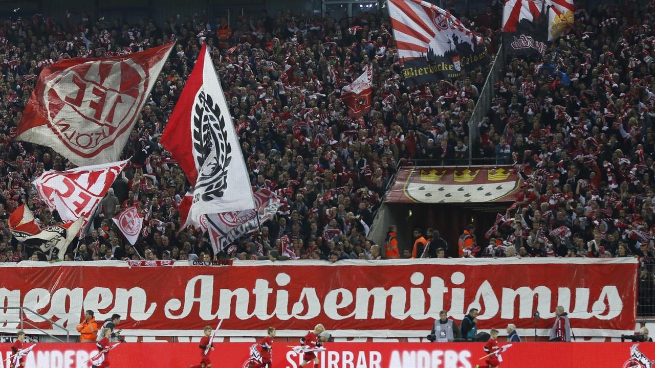 Kölner Fußballfans halten ein großes Plakat mit der Aufschrift "Gegen Antisemitismus" hoch - im Spiel zwischen dem 1. FC Koeln und HSV Hamburg in der Saison 2016/2017.