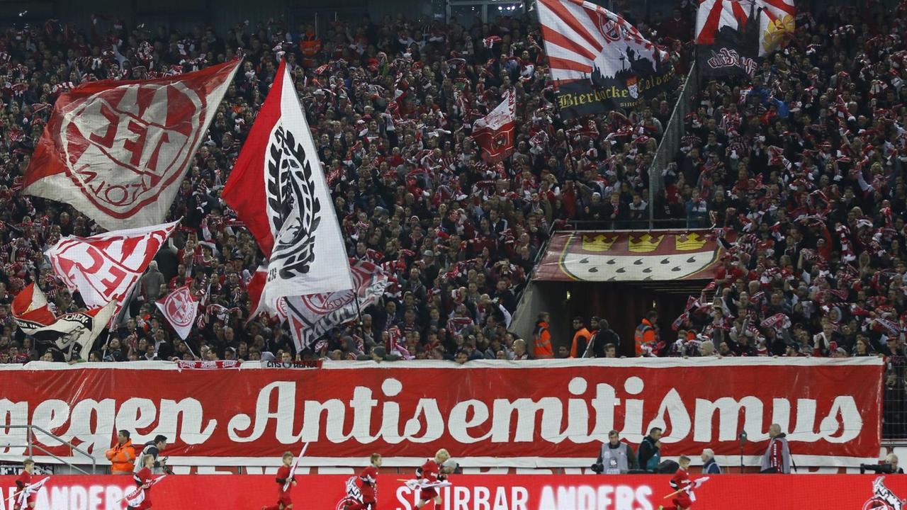 Kölner Fußballfans halten ein großes Plakat mit der Aufschrift "Gegen Antisemitismus" hoch - im Spiel zwischen dem 1. FC Koeln und HSV Hamburg in der Saison 2016/2017. Kölner Fußballfans halten ein großes Plakat mit der Aufschrift "Gegen Antisemitismus" hoch - im Spiel zwischen dem 1. FC Koeln und HSV Hamburg in der Saison 2016/2017.