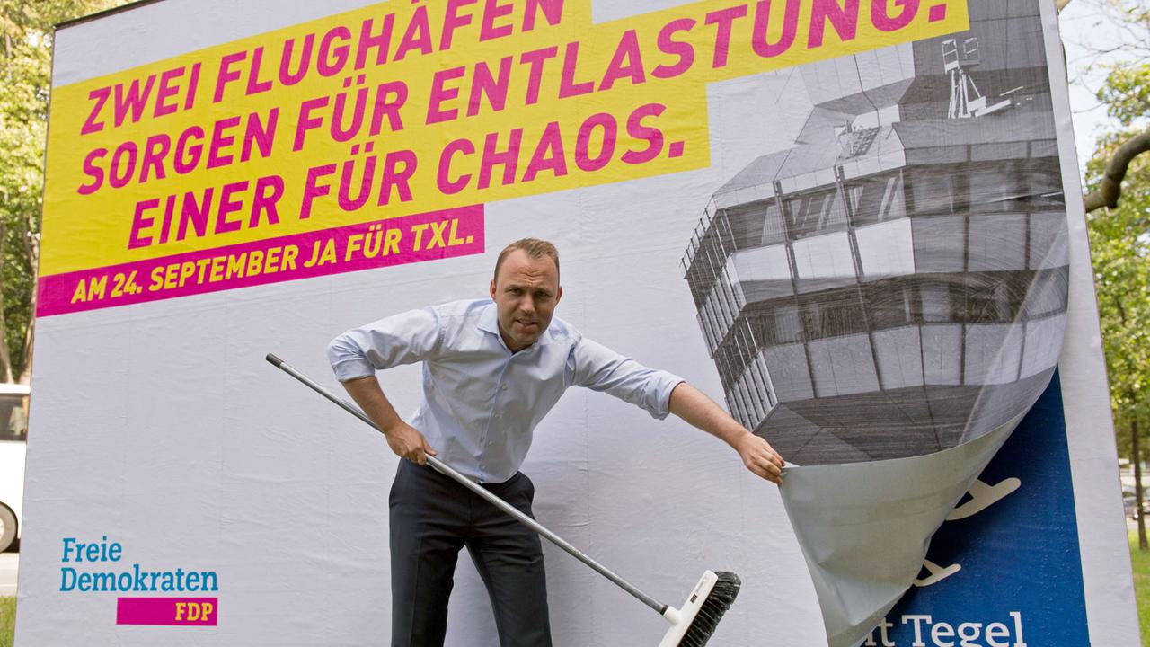 "Zwei Flughäfen sorgen für Entlastung, einer für Chaos" steht am 15.09.2017 in Berlin auf dem neuen Plakat der Berliner FDP, das deren Generalsekretär Sebastian Czaja anbringt. Bei der anstehenden Bundestagswahl findet auch ein Volksentscheid statt.
