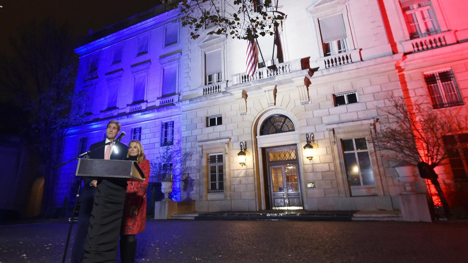US-Außenminister John Kerry vor der in den französischen Nationalfarben angestrahlten US-Botschaft US-Außenminister John Kerry vor der in den französischen Nationalfarben angestrahlten US-Botschaft