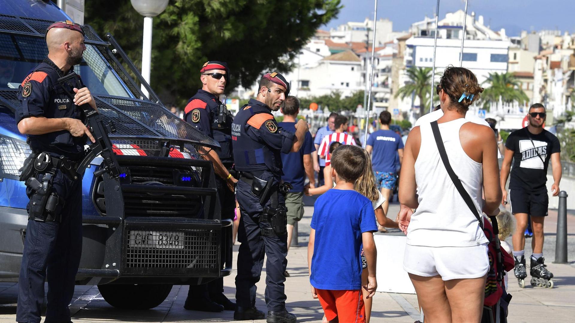 Zu sehen sind Passanten und spanische Polizisten am 18.8.2017 im Urlaubsort Cambrils.