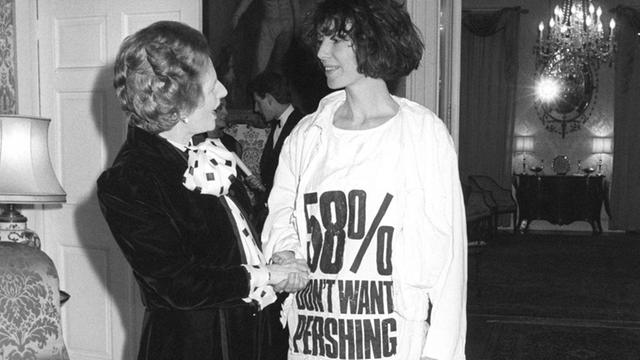 Die damalige britische Premierministerin Margaret Thatcher begrüßt am 17. März 1984 die Modedesignerin Katharine Hamnett, die ein T-Shirt als Protest gegen die nukleare Pershing-Rakete trägt.