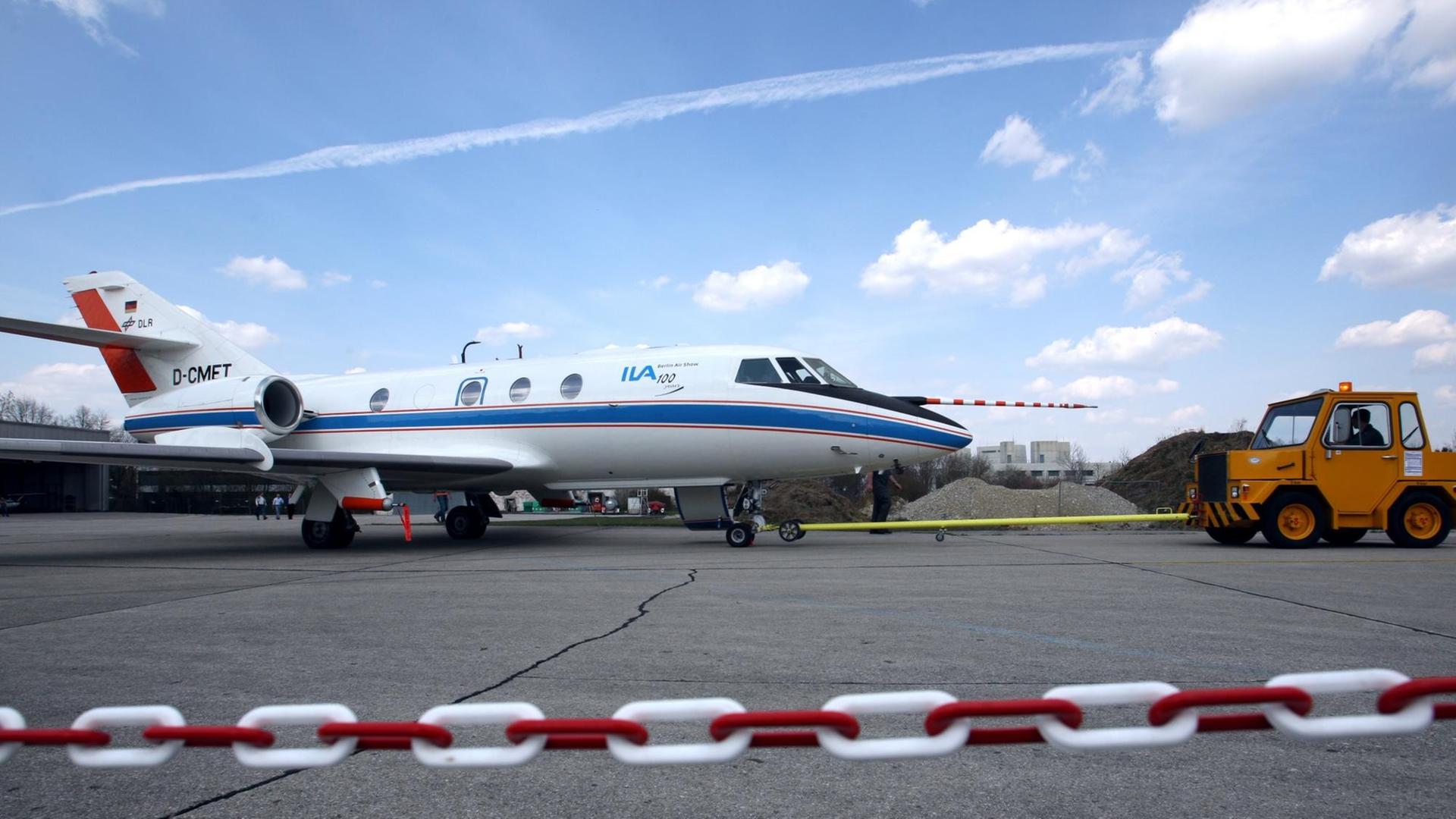 Das Forschungsflugzeug vom Typ Dassault Falcon 20E wird auf dem Flugplatz des Deutschen Zentrums für Luft- und Raumfahrt (DLR) in Oberpfaffenhofen zur Startbahn gezogen