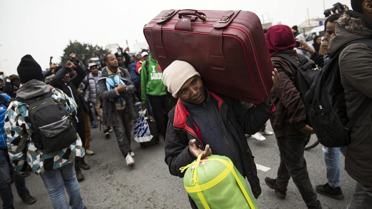 Ein Flüchtling aus Äthiopien wird von der französischen Polizei aus dem Flüchtlingslager in Calais begleitet. Ein Flüchtling aus Äthiopien wird von der französischen Polizei aus dem Flüchtlingslager in Calais begleitet.