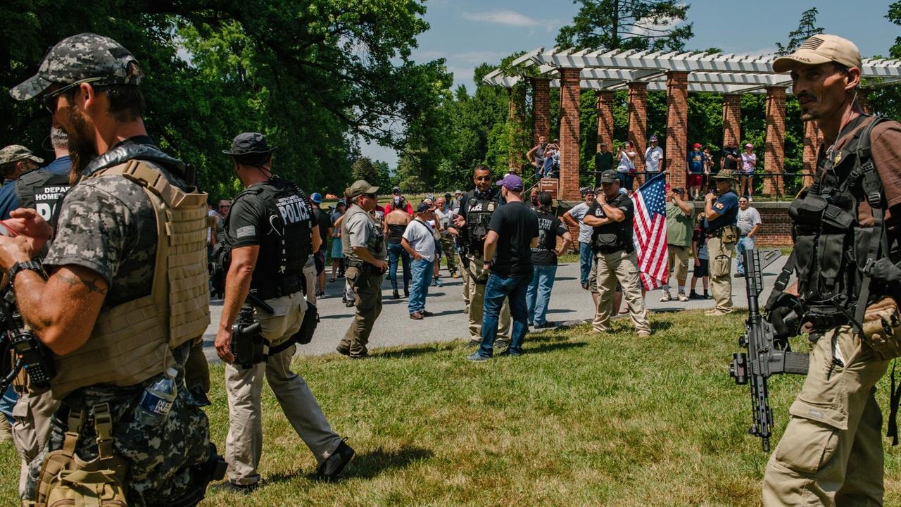 Schwer bewaffnete Nationalisten und Polizisten auf einer Kundgebung im Gettysburg National Military Park. Schwer bewaffnete Nationalisten und Polizisten auf einer Kundgebung im Gettysburg National Military Park.