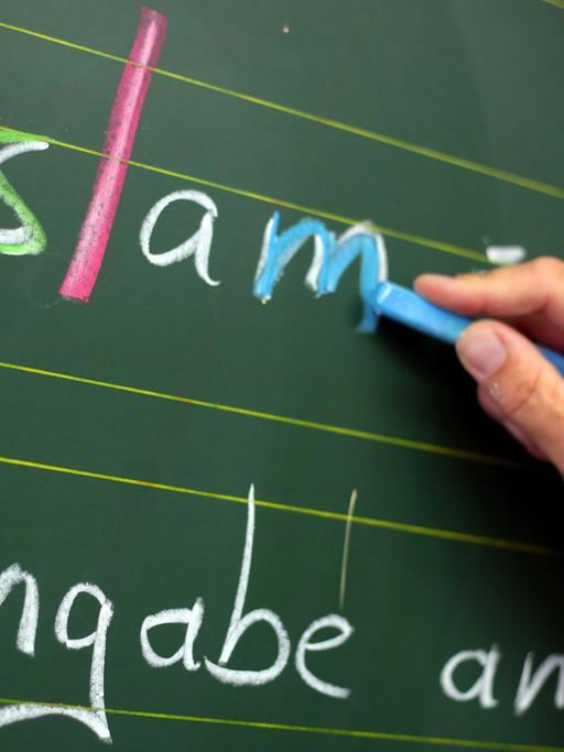 Der Religionslehrer Ridwan Bauknecht schreibt am Montag (27.08.2012) in Bonn an der Robert-Koch-Schule während des islamischen Religionsunterrichts an die Tafel.