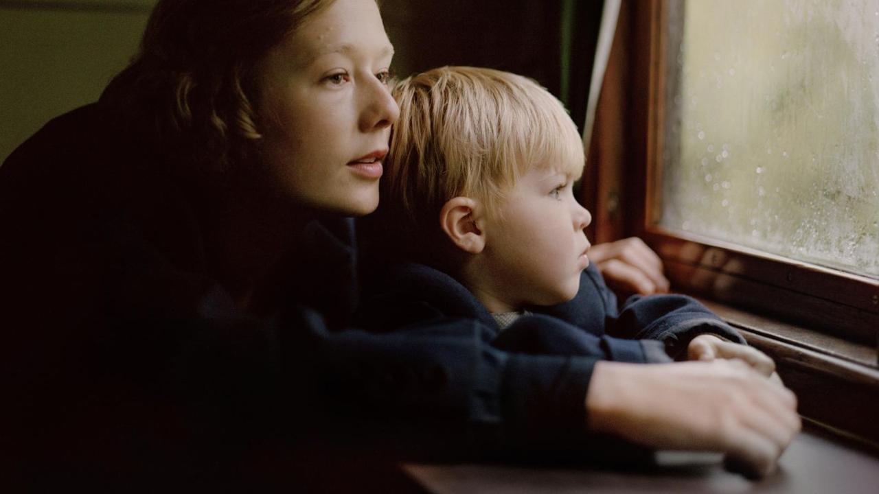 Die junge Astrid Lindgren hält ihren Sohn im Arm und blickt aus einem Fenster. Die junge Astrid Lindgren hält ihren Sohn im Arm und blickt aus einem Fenster.