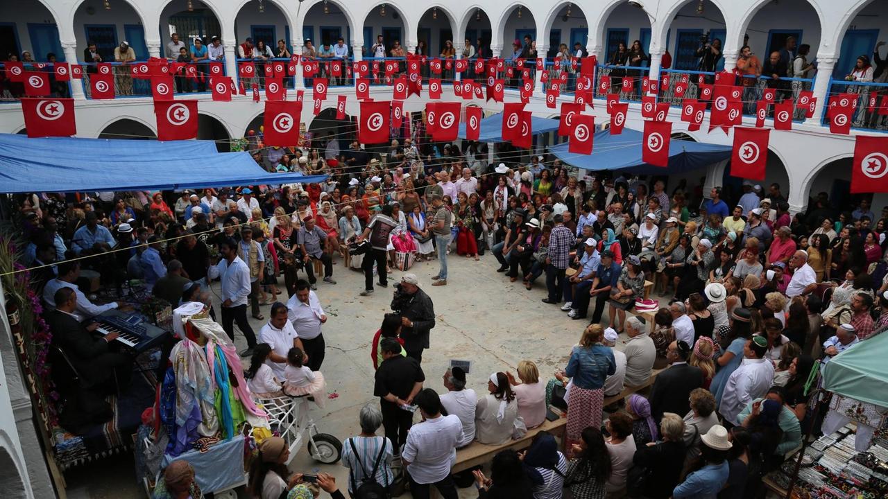 Auktion in der alten Karawanserei der tunesischen Insel Djerba: Bevor die Prozession zur Synagoge La Ghriba beginnt, werden hier allerlei religiöse Symbole verteigert. Foto: Imago Auktion in der alten Karawanserei der tunesischen Insel Djerba: Bevor die Prozession zur Synagoge La Ghriba beginnt, werden hier allerlei religiöse Symbole verteigert. Foto: Imago