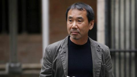 Haruki Murakami mit seinem Werk "1Q84" in der Hand