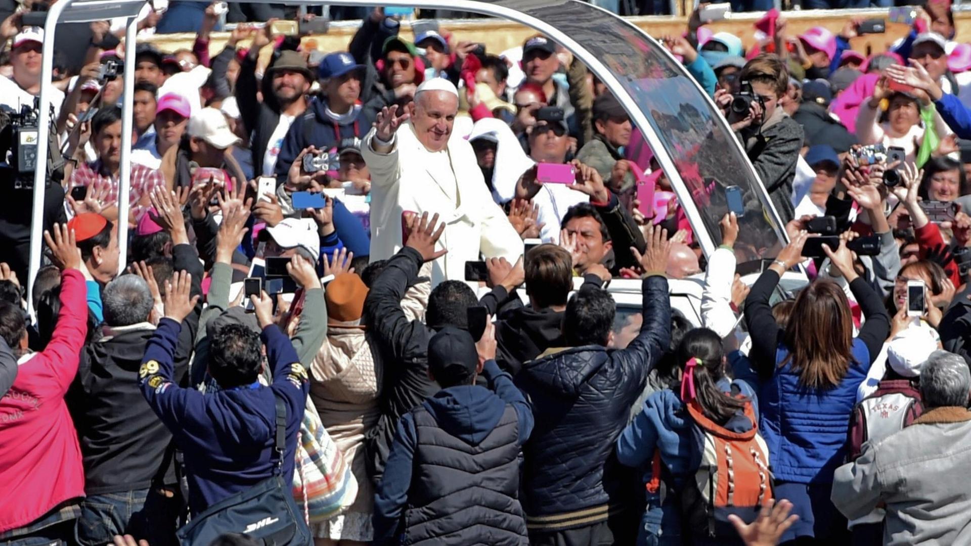 Papst Franziskus wird bei seiner Fahrt durch die Straßen von Mexiko-Stadt von tausenden Menschen umringt und bejubelt. Papst Franziskus wird bei seiner Fahrt durch die Straßen von Mexiko-Stadt von tausenden Menschen umringt und bejubelt.