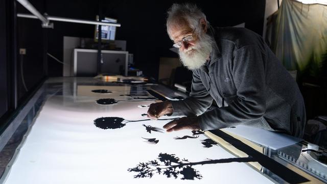 Jörg Herrmann, Silhouettenfilm-Macher, arbeitet in seiner Werkstatt an einer Filmszene. Trotz der modernen Technik pflegt der 77-Jährige die alte Kunst der manuellen Silhouettenanimation. Er ist einer der letzten aktiven Silhouettenfilmer weltweit.