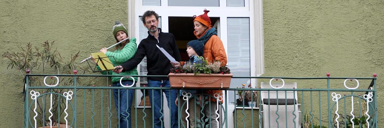 Eine Familie in München singt auf dem Balkon ihrer Wohnung und beteiligt sich damit an einer bayernweiten Aktion.