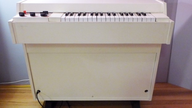 Ein weißes Instrument mit Tastatur, ähnlich einem Klavier.
