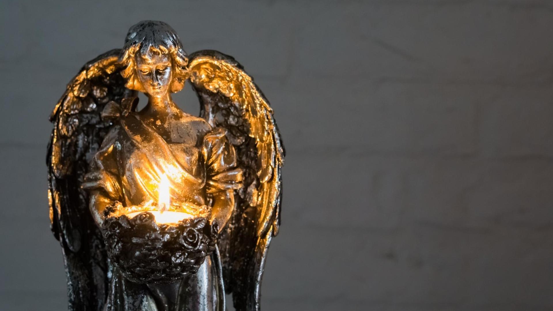 Silberne Engelfigur, die eine Kerze hält Silberne Engelfigur, die eine Kerze hält