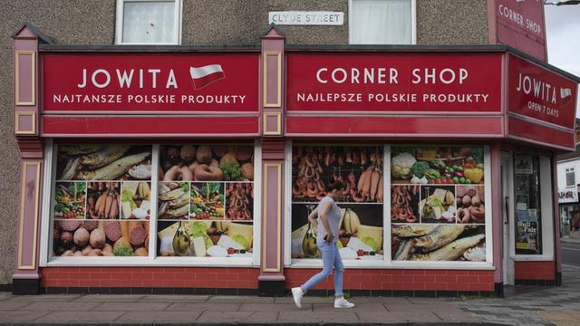 Eine Frau läuft an einem polnischen Supermarkt in Grimsby, England, vorbei.