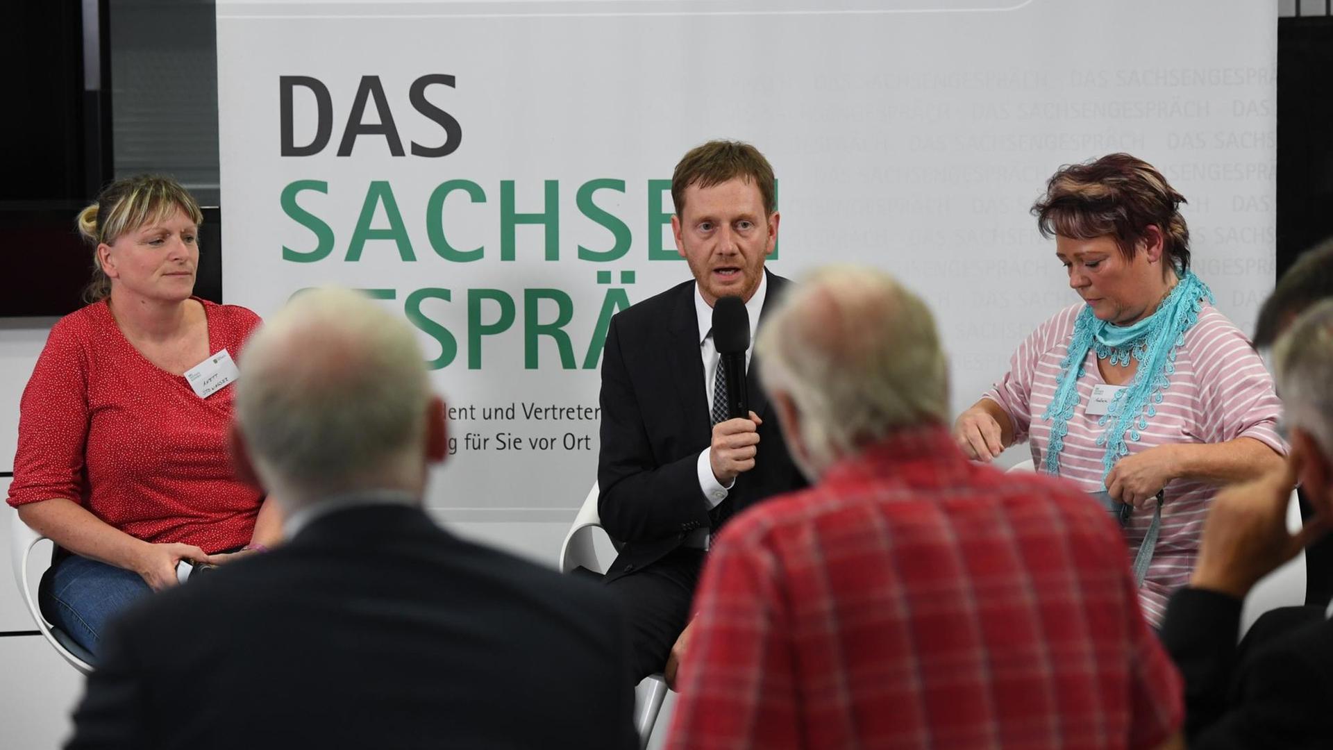 Der Ministerpräsident von Sachsen, Michael Kretschmer (CDU) unterhält sich mit Bürgern beim Sachsengespräch in Chemnitz.