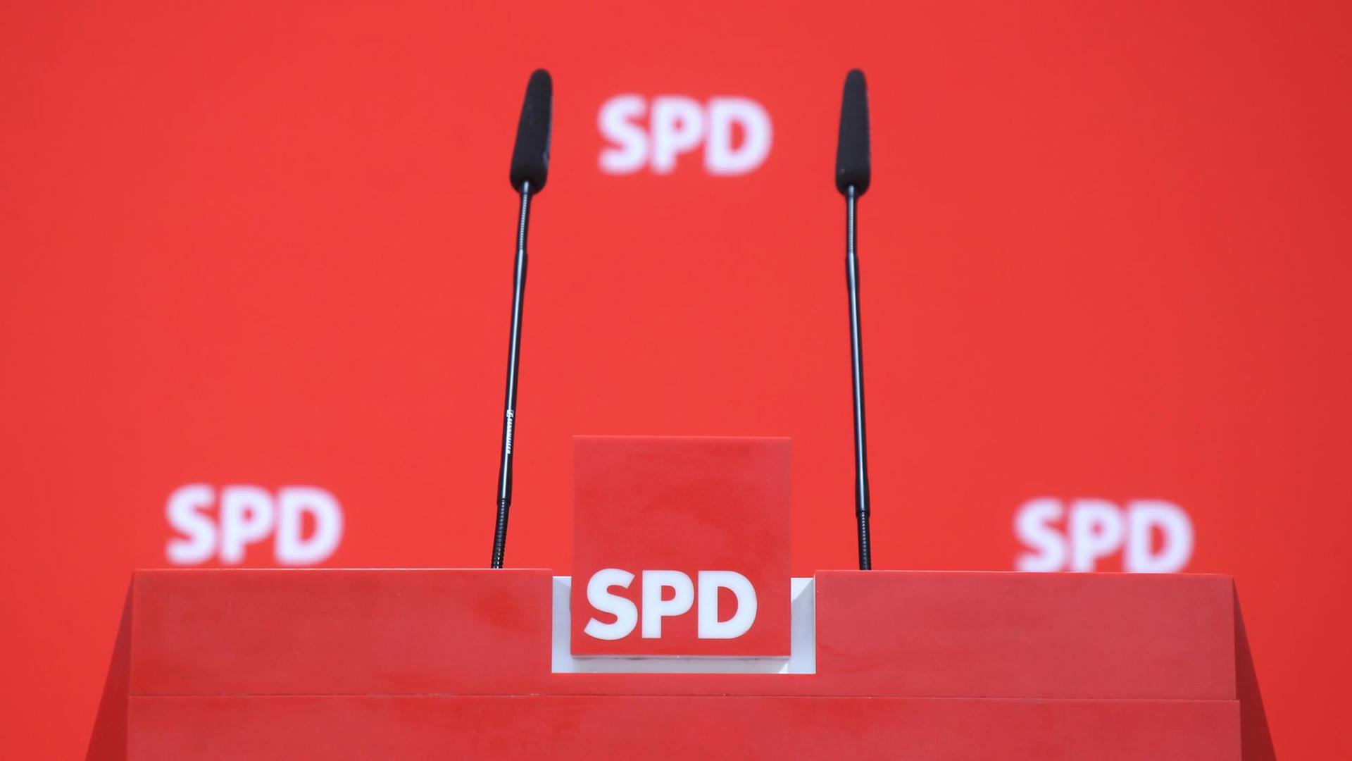 Drei SPD-Logos sind im Hintergrund eines Rednerpultes zu sehen. Drei SPD-Logos sind im Hintergrund eines Rednerpultes zu sehen.