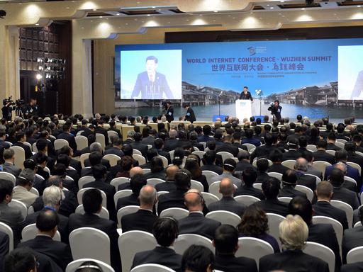 Xi Jinping spricht auf einer Bühne vor einem großen Auditorium.
