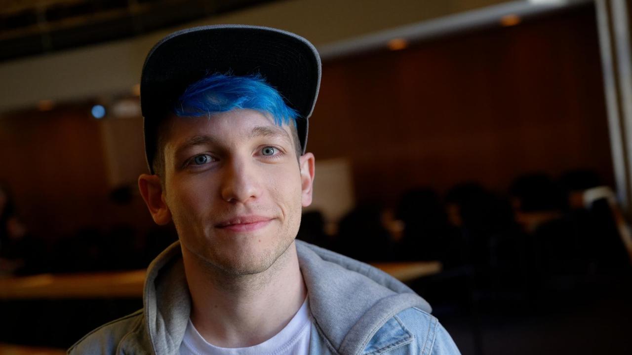 Ein Mann mit blauen Haaren und Basecap Ein Mann mit blauen Haaren und Basecap
