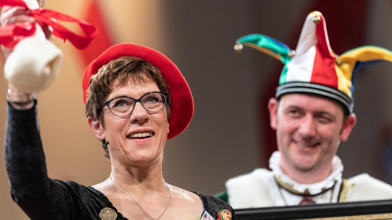 Die Bundesvorsitzende der CDU, Annegret Kramp-Karrenbauer, steht vor dem Narrengericht und hält einen Plastikknochen in der Hand.
