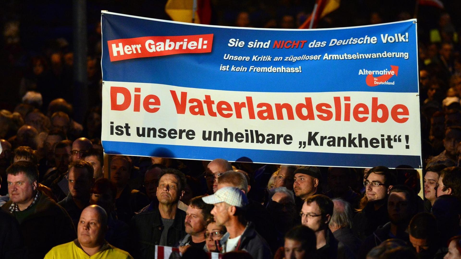 Demonstranten protestieren mit einem Banner und der Aufschrift "Herr Gabriel: Sie sind nicht das Volk! Unsere Kritik an zügelloser Armutseinwanderung ist kein Fremdenhass! Die Vaterlandsliebe ist unsere unheilbare 'Krankheit'!" am 07.10.2015 in Erfurt (Thüringen) gegen die Asylpolitik. Die rechtskonservative AfD hatte zur Demonstration aufgerufen. Die Polizei sprach zum Auftakt der Kundgebung von 5000 Teilnehmern, die Zahl der Gegendemonstranten wurde mit 800 angegeben. Demonstranten protestieren mit einem Banner und der Aufschrift "Herr Gabriel: Sie sind nicht das Volk! Unsere Kritik an zügelloser Armutseinwanderung ist kein Fremdenhass! Die Vaterlandsliebe ist unsere unheilbare 'Krankheit'!" am 07.10.2015 in Erfurt (Thüringen) gegen die Asylpolitik. Die rechtskonservative AfD hatte zur Demonstration aufgerufen. Die Polizei sprach zum Auftakt der Kundgebung von 5000 Teilnehmern, die Zahl der Gegendemonstranten wurde mit 800 angegeben.