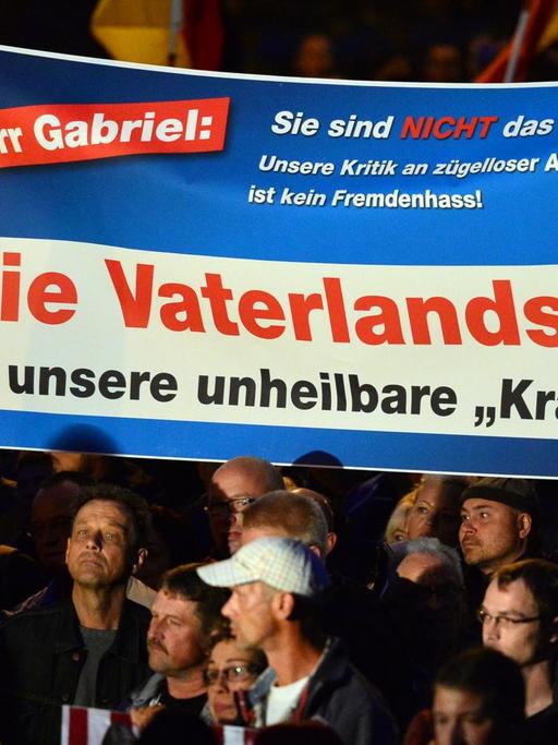 Demonstranten protestieren mit einem Banner und der Aufschrift "Herr Gabriel: Sie sind nicht das Volk! Unsere Kritik an zügelloser Armutseinwanderung ist kein Fremdenhass! Die Vaterlandsliebe ist unsere unheilbare 'Krankheit'!" am 07.10.2015 in Erfurt (Thüringen) gegen die Asylpolitik. Die rechtskonservative AfD hatte zur Demonstration aufgerufen. Die Polizei sprach zum Auftakt der Kundgebung von 5000 Teilnehmern, die Zahl der Gegendemonstranten wurde mit 800 angegeben.