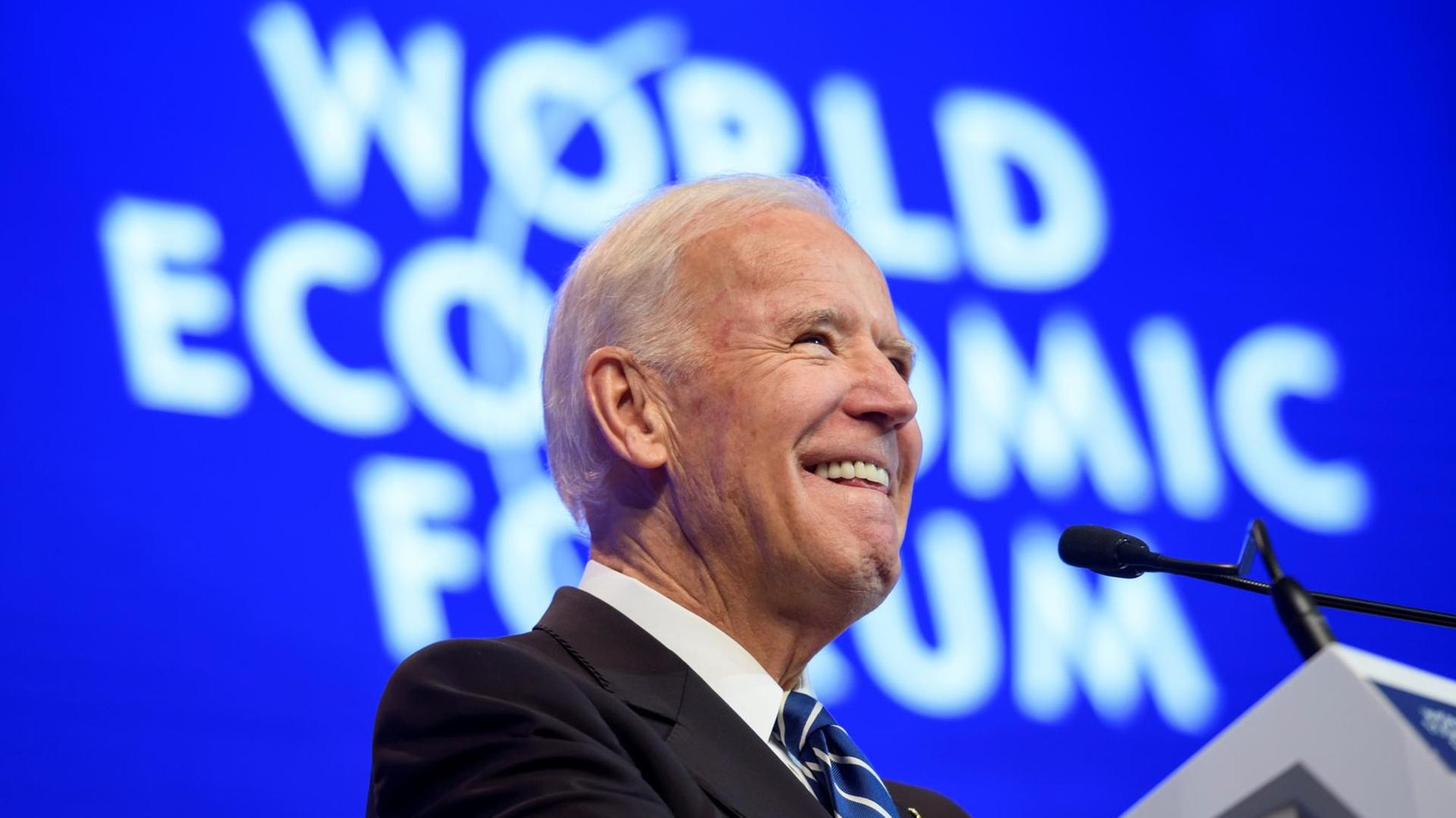 Biden lächelt am Rednerpult, im Hintergrund der Schriftzug "World Economic Forum"