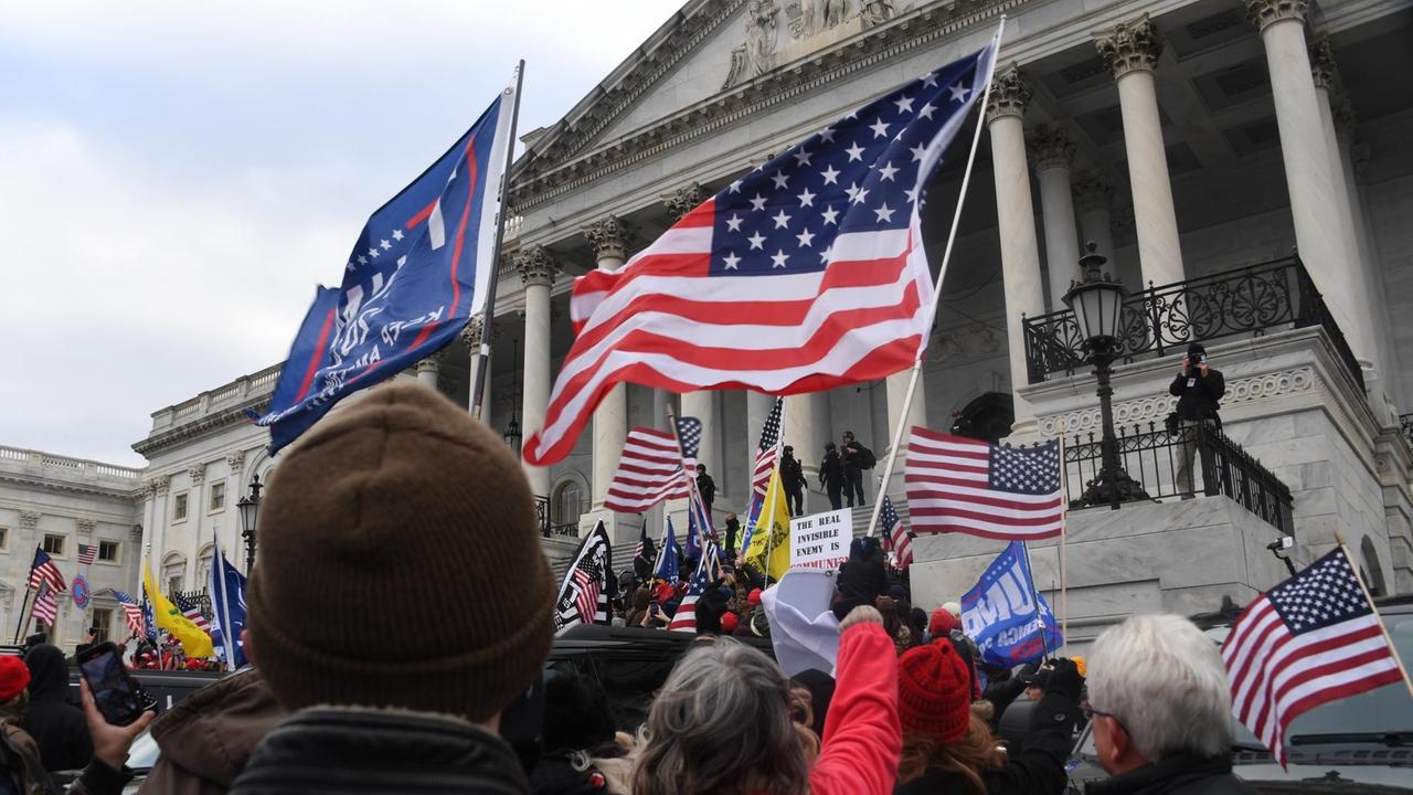Menschen mit USA- und andren Flaggen erstürme am 6. Januar 2021 das US-Kapitol in Washington, DC. Menschen mit USA- und andren Flaggen erstürme am 6. Januar 2021 das US-Kapitol in Washington, DC.