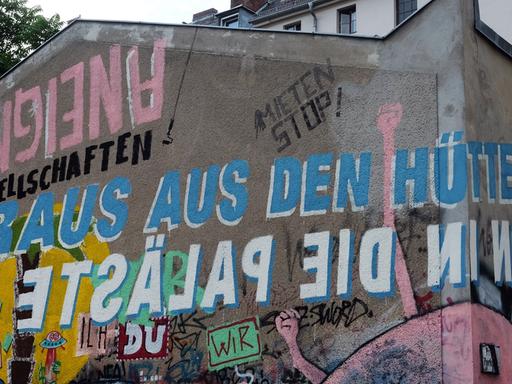 "Raus aus den Hütten. Rein in die Paläste" steht in Berlin an einer Häuserwand in der Gneisenaustraße in Kreuzberg, aufgenommen 2017