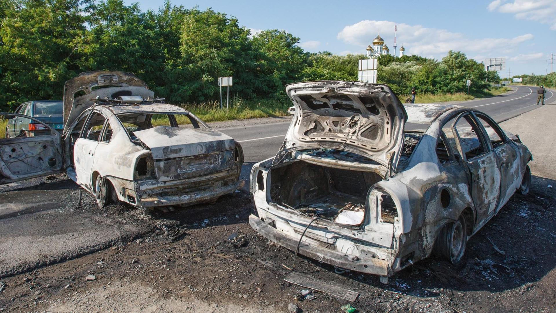 Zwei ausgebrannte Autos auf einer Straße Richtung Mukatschewe im Südwesten der Ukraine. Zwei ausgebrannte Autos auf einer Straße Richtung Mukatschewe im Südwesten der Ukraine.