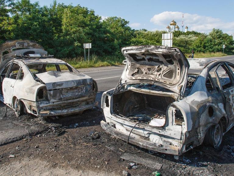 Zwei ausgebrannte Autos auf einer Straße Richtung Mukatschewe im Südwesten der Ukraine.
