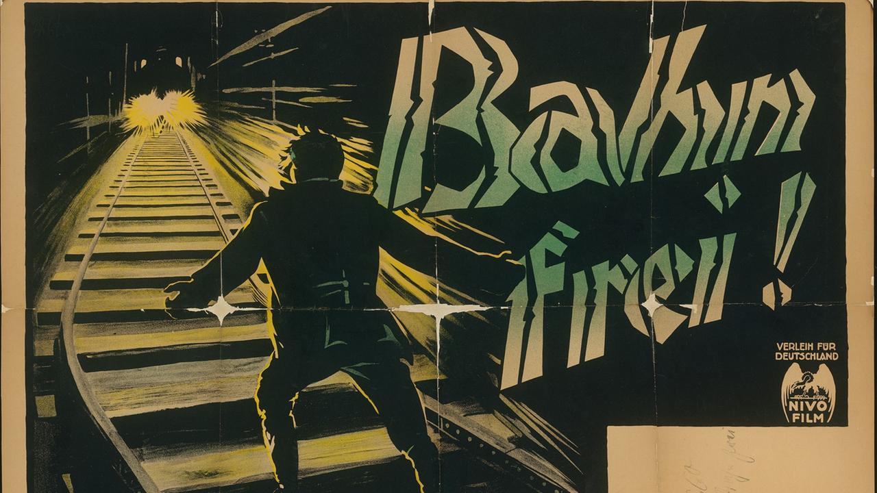 Das alte Filmplakat von "Bahn frei!" zeigt eine Illustration eines Mannes auf Zuggleisen, während ein Zug auf ihn zufährt. Das alte Filmplakat von "Bahn frei!" zeigt eine Illustration eines Mannes auf Zuggleisen, während ein Zug auf ihn zufährt.