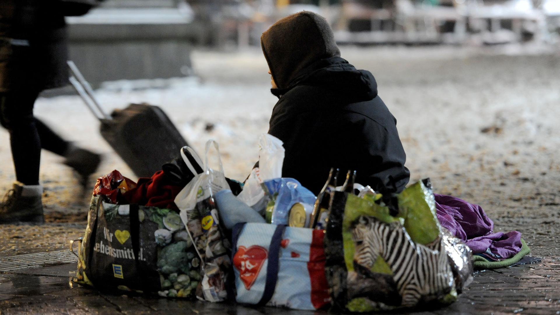 Ein obdachloser Mann sitzt im Winter auf dem Vorplatz des Hauptbahnhofes in Bremen. Ein obdachloser Mann sitzt im Winter auf dem Vorplatz des Hauptbahnhofes in Bremen.