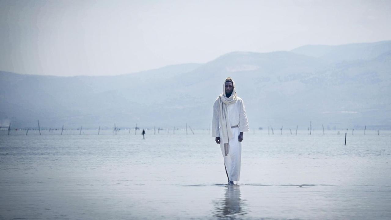 Eine Filmszene zeigt Yvan Sagnet der als schwarzer Jesus über das Wasser wandelt. Eine Filmszene zeigt Yvan Sagnet der als schwarzer Jesus über das Wasser wandelt.