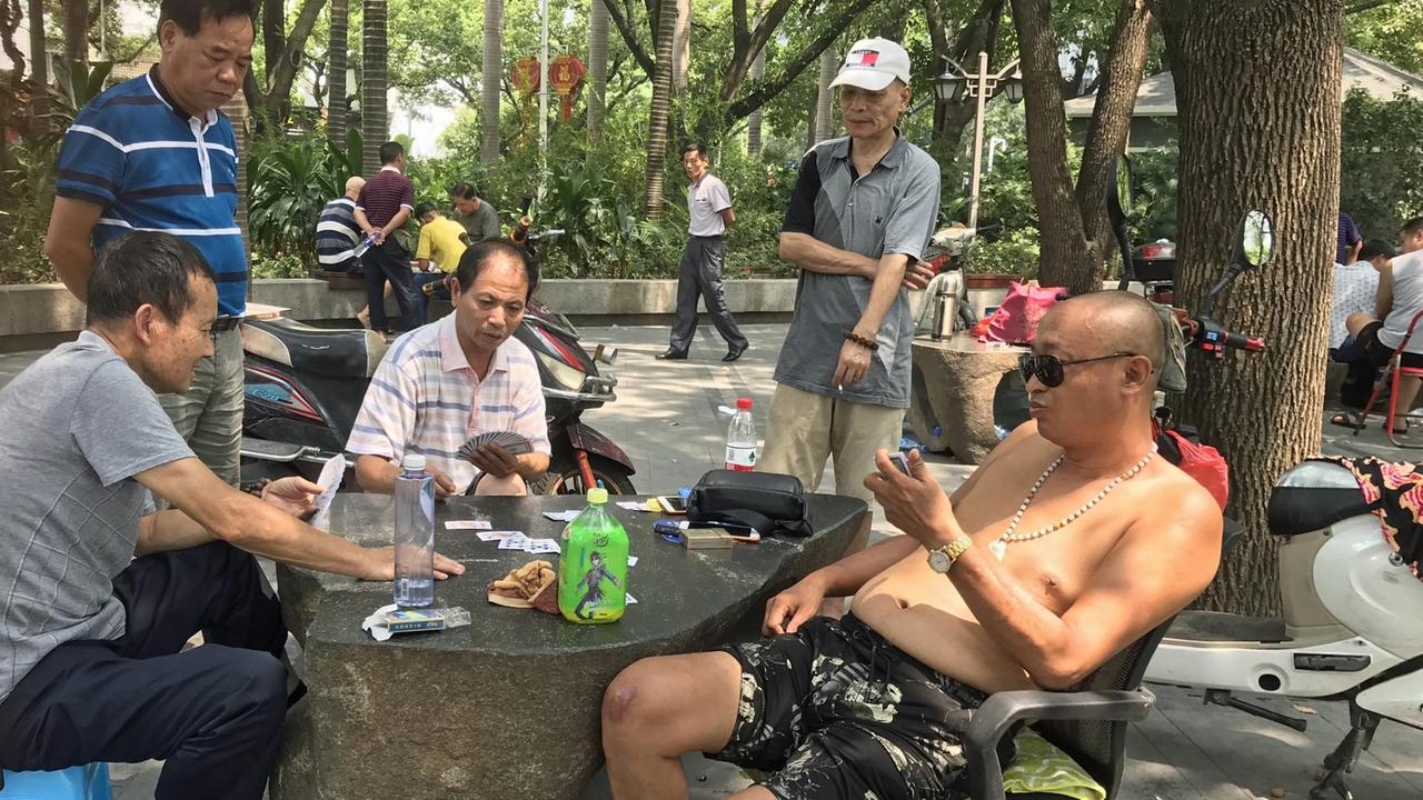 Fünf Männer sitzen in einem Park in der südchinesischen Stadt Fuzhou, spielen Karten und sprechen über Politik Fünf Männer sitzen in einem Park in der südchinesischen Stadt Fuzhou, spielen Karten und sprechen über Politik