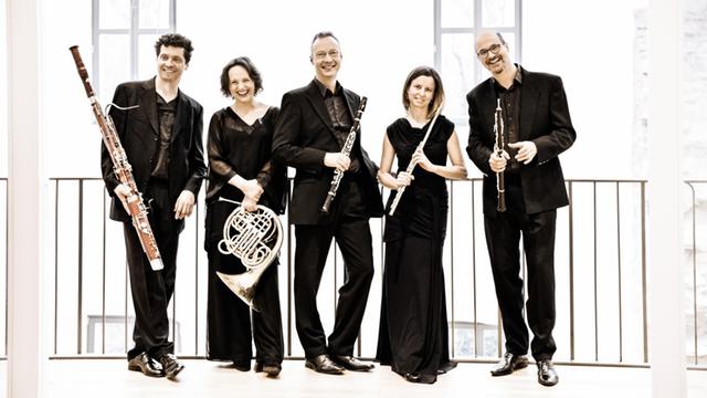 Das Bild zeigt das Maalot Quintett vor einem Geländer stehen. Die Musiker sind schwarz gekleidet und jeder hat sein Instrument in der Hand.
